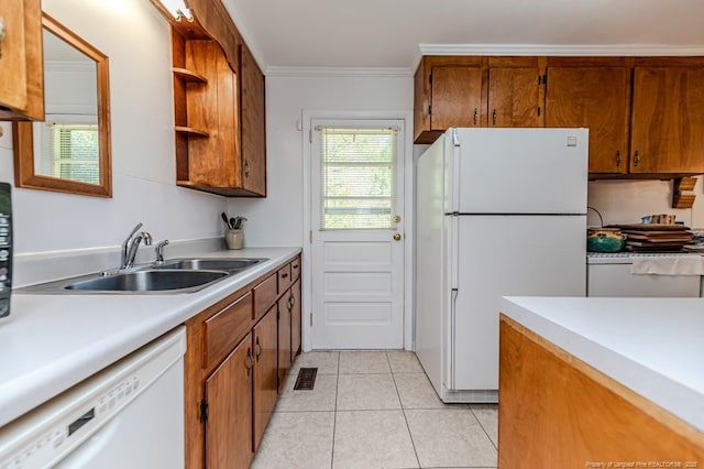 kitchen with brown cabinets, white appliances, light countertops, and a sink
