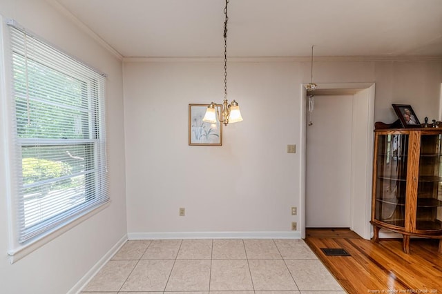 unfurnished dining area featuring light tile patterned floors, visible vents, crown molding, and baseboards