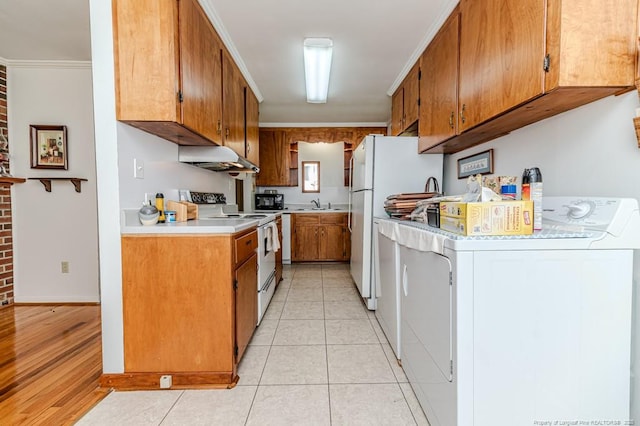 kitchen with brown cabinets, crown molding, washer / clothes dryer, light countertops, and white appliances