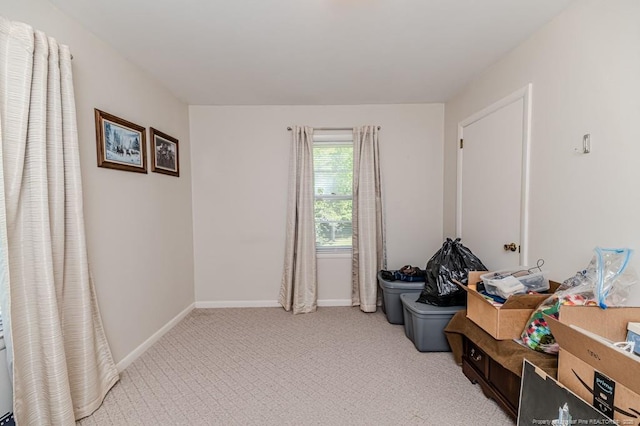 empty room featuring light carpet and baseboards
