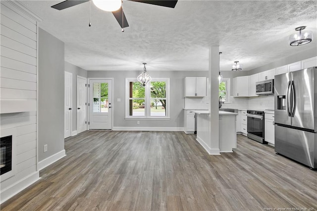 1833 Faber St, Fayetteville, NC 28304 - kitchen with wood finished floors, stainless steel appliances, light countertops, and ceiling fan with notable chandelier