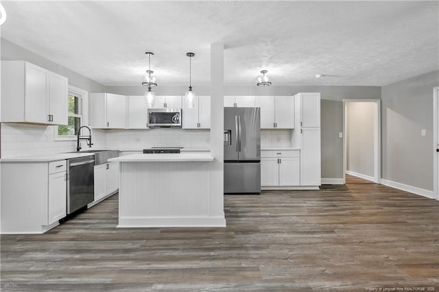 1833 Faber St, Fayetteville, NC 28304 - kitchen featuring white cabinets, backsplash, dark wood-style flooring, and appliances with stainless steel finishes