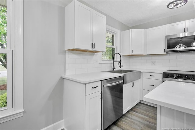 1833 Faber St, Fayetteville, NC 28304 - kitchen featuring wood finished floors, stainless steel appliances, light countertops, white cabinets, and a sink
