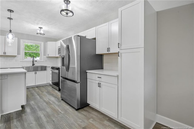1833 Faber St, Fayetteville, NC 28304 - kitchen with stainless steel appliances, light wood-style floors, decorative backsplash, and a sink