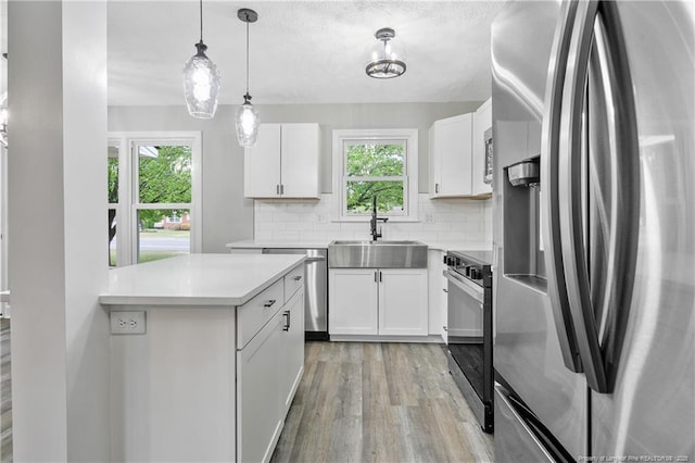 1833 Faber St, Fayetteville, NC 28304 - kitchen featuring appliances with stainless steel finishes, light countertops, backsplash, light wood finished floors, and a sink