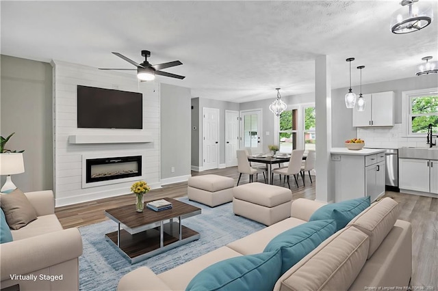 1833 Faber St, Fayetteville, NC 28304 - living room featuring a chandelier, light wood-type flooring, ceiling fan, and a large fireplace
