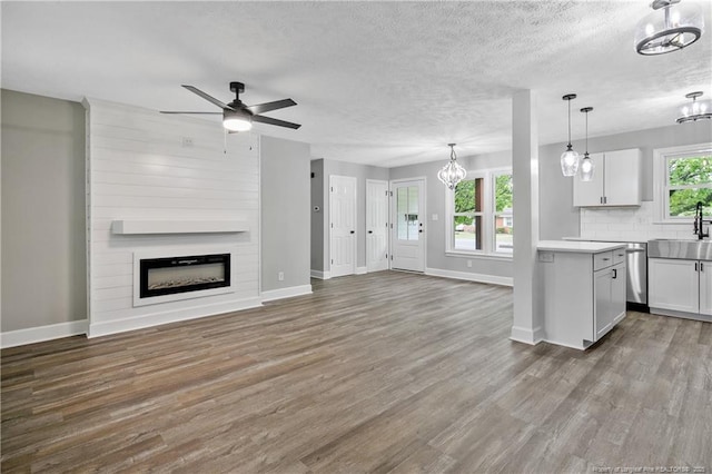 1833 Faber St, Fayetteville, NC 28304 - kitchen featuring a chandelier, open floor plan, a fireplace, a ceiling fan, and wood finished floors