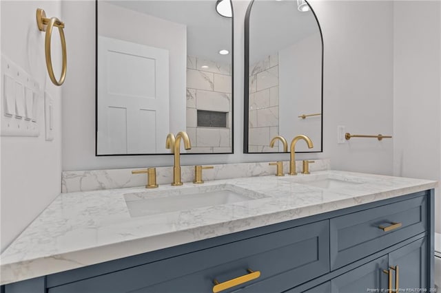 full bathroom with recessed lighting, double vanity, and a sink