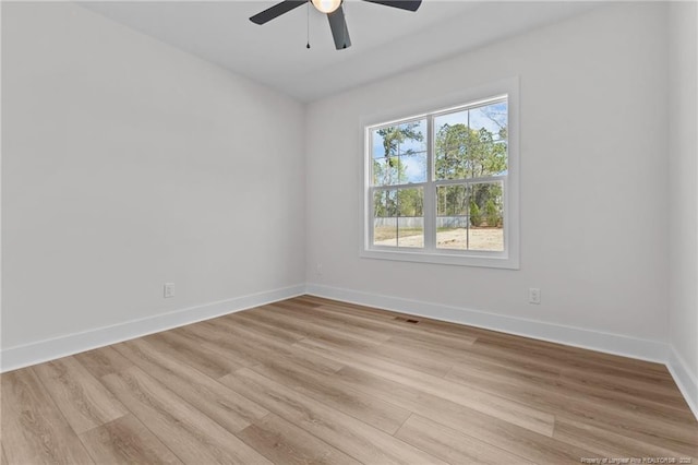 empty room featuring baseboards, a ceiling fan, and light wood finished floors