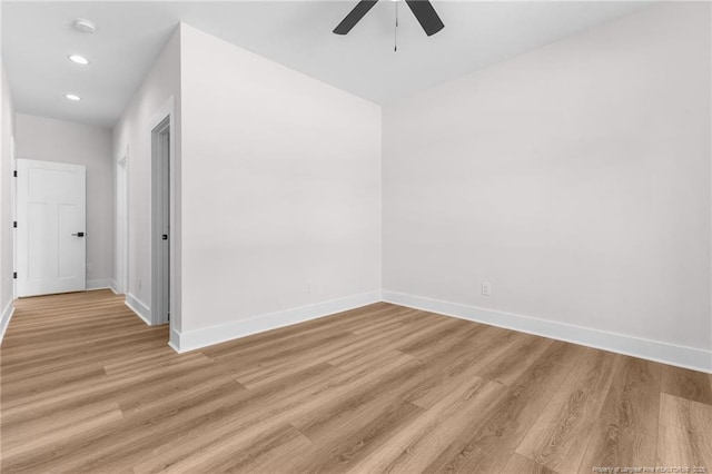 spare room featuring baseboards, recessed lighting, a ceiling fan, and light wood-style flooring