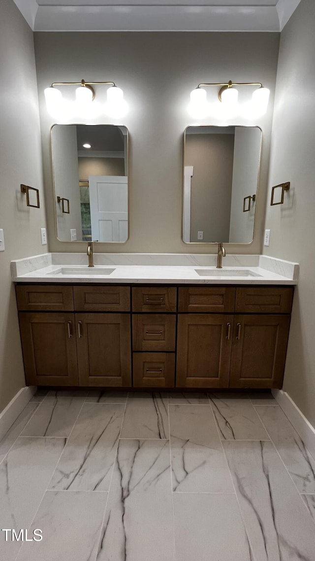 full bathroom featuring double vanity, baseboards, a sink, and marble finish floor