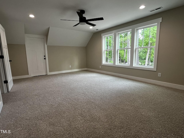 additional living space featuring a ceiling fan, visible vents, baseboards, lofted ceiling, and carpet flooring