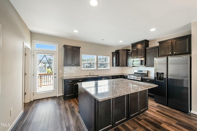 kitchen with a center island, a sink, dark wood finished floors, and stainless steel appliances
