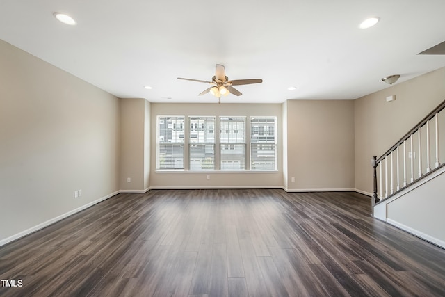 unfurnished living room with ceiling fan, recessed lighting, baseboards, dark wood-type flooring, and stairway