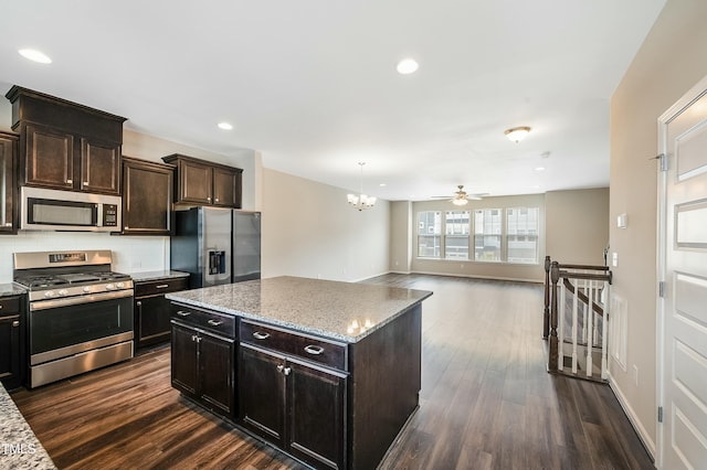 kitchen featuring dark wood-type flooring, backsplash, light stone countertops, and stainless steel appliances