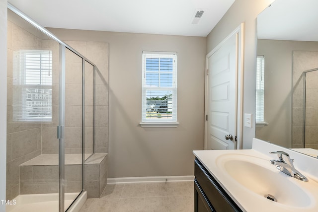 full bath featuring tile patterned flooring, vanity, visible vents, baseboards, and a shower stall