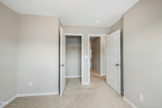 unfurnished bedroom with baseboards, carpet, and a closet