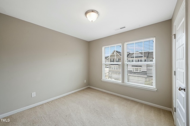 carpeted empty room featuring baseboards and visible vents