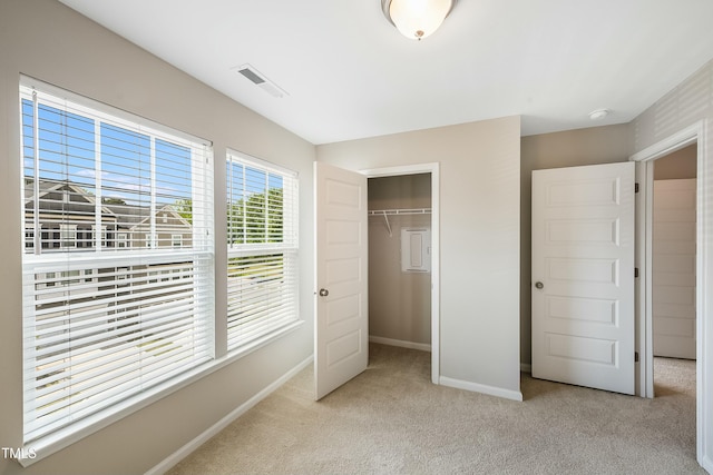 unfurnished bedroom with a closet, baseboards, light colored carpet, and visible vents