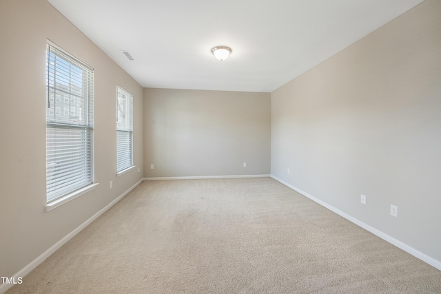 empty room with a healthy amount of sunlight and baseboards