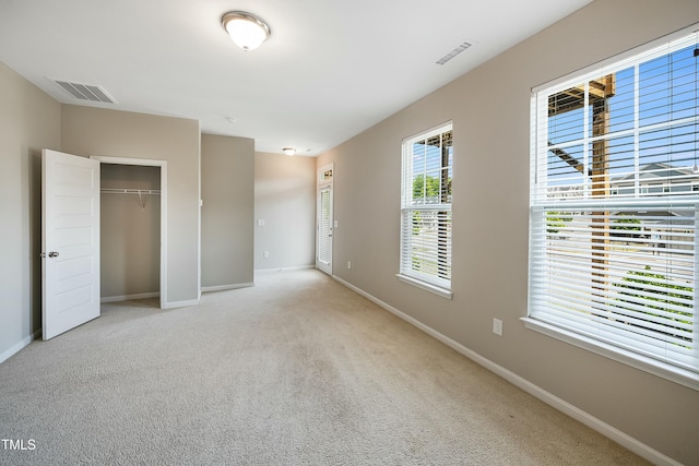 unfurnished bedroom with carpet flooring, baseboards, and visible vents