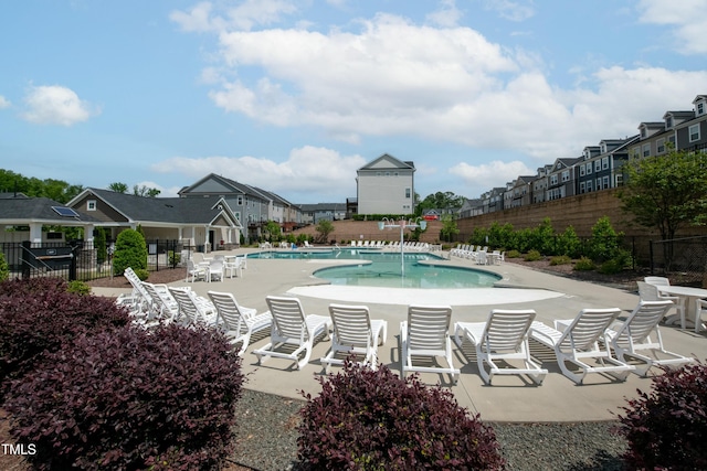 pool featuring a patio, fence, and a residential view