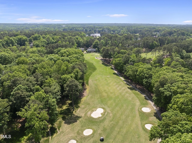 birds eye view of property with golf course view and a forest view