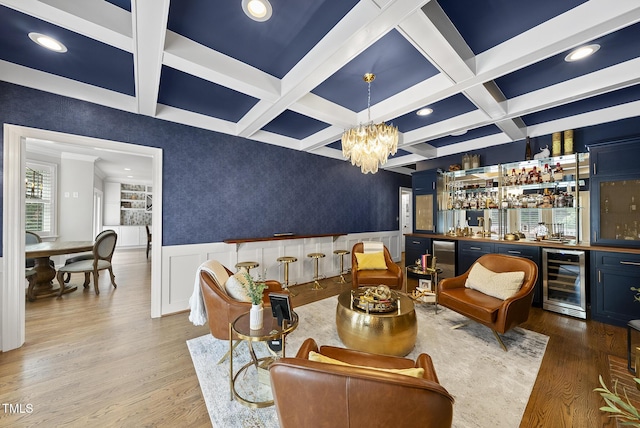 living area featuring beverage cooler, bar area, wood finished floors, and coffered ceiling