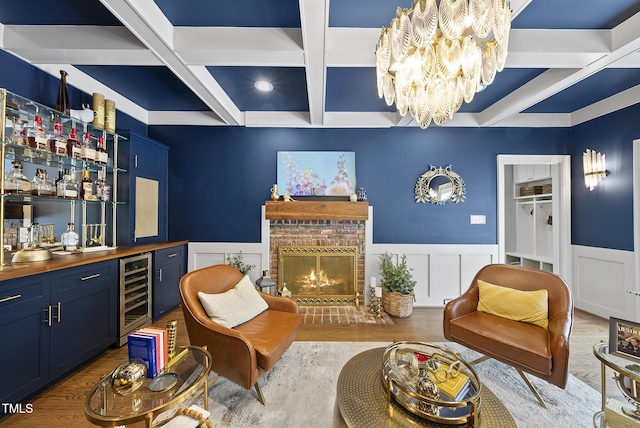 interior space featuring an inviting chandelier, bar, beam ceiling, beverage cooler, and coffered ceiling