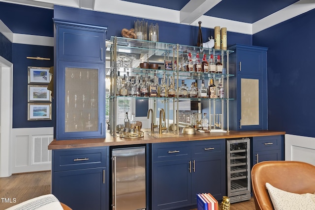 bar with wet bar, visible vents, wood finished floors, and wine cooler