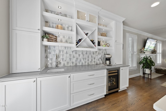 bar featuring crown molding, a sink, indoor wet bar, tasteful backsplash, and wine cooler