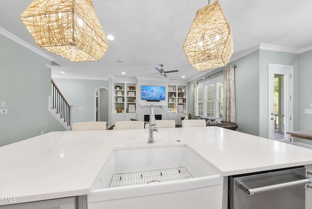 kitchen with ceiling fan, crown molding, arched walkways, a sink, and open floor plan