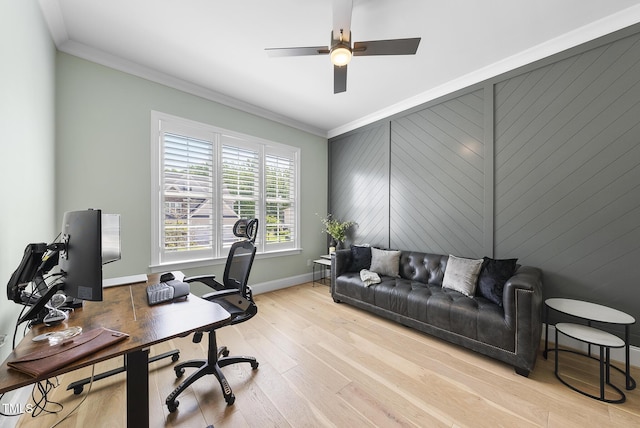 home office featuring a ceiling fan, baseboards, ornamental molding, and light wood-style floors