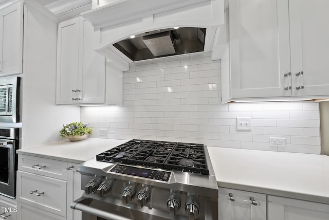 kitchen featuring light countertops, stainless steel appliances, white cabinetry, and tasteful backsplash