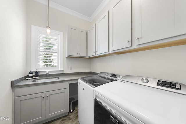 washroom with crown molding, a sink, cabinet space, and washer and clothes dryer