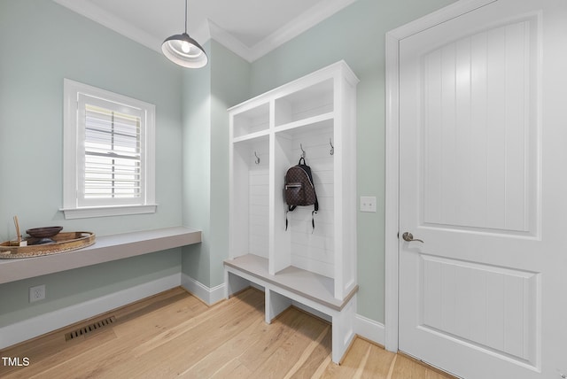 mudroom with visible vents, ornamental molding, light wood-style flooring, and baseboards