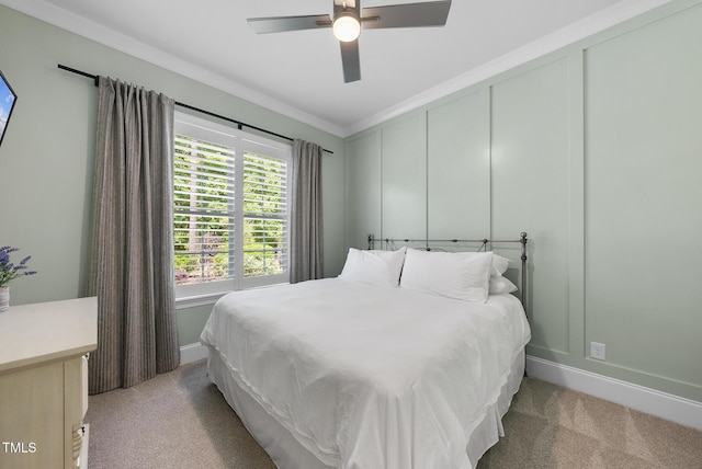 bedroom featuring crown molding, baseboards, a decorative wall, and light carpet