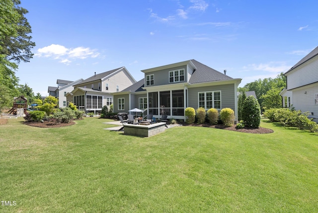 back of property featuring a sunroom, a playground, and a lawn