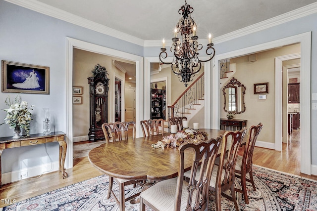 1605 Hunting Ridge Rd, Raleigh, NC 27615 - dining space featuring baseboards, light wood-type flooring, ornamental molding, a notable chandelier, and stairs