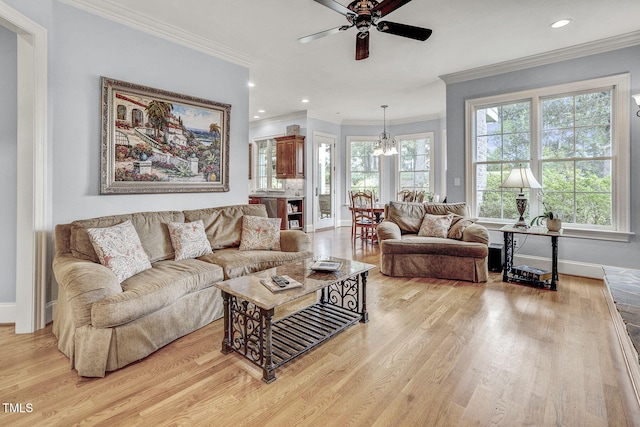 1605 Hunting Ridge Rd, Raleigh, NC 27615 - living room featuring light wood-style flooring, baseboards, ornamental molding, and ceiling fan with notable chandelier