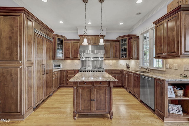 1605 Hunting Ridge Rd, Raleigh, NC 27615 - kitchen with stainless steel dishwasher, a center island, under cabinet range hood, light wood-type flooring, and light stone countertops