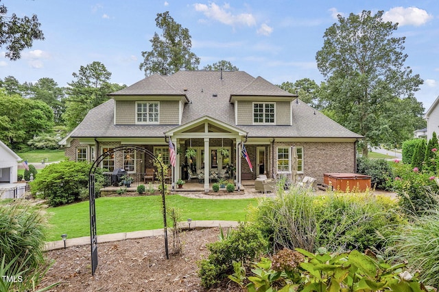 1605 Hunting Ridge Rd, Raleigh, NC 27615 - back of house featuring a lawn, roof with shingles, a hot tub, and a patio area