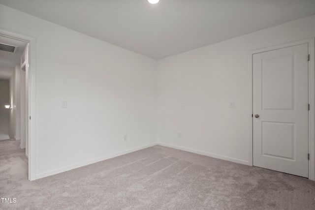 spare room with light carpet and baseboards