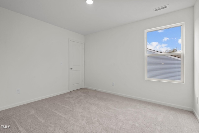 carpeted spare room featuring baseboards
