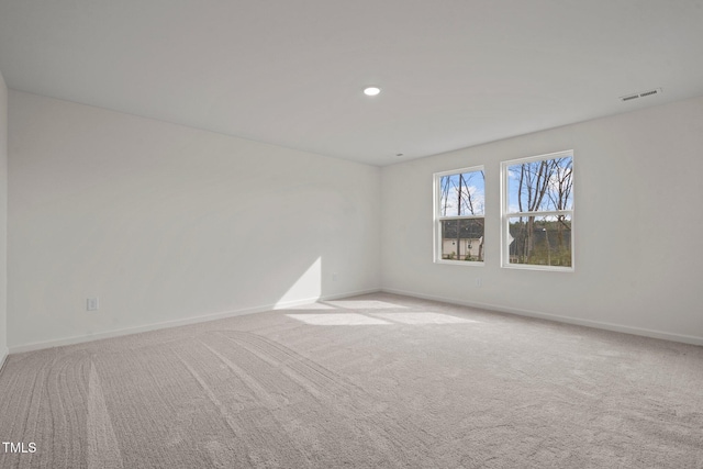 unfurnished room with baseboards, light carpet, and recessed lighting
