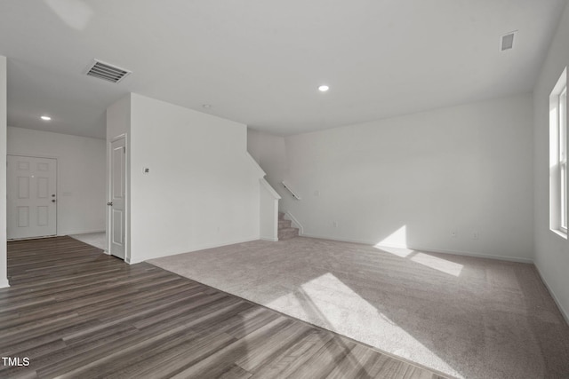 unfurnished living room with stairway, wood finished floors, recessed lighting, and baseboards