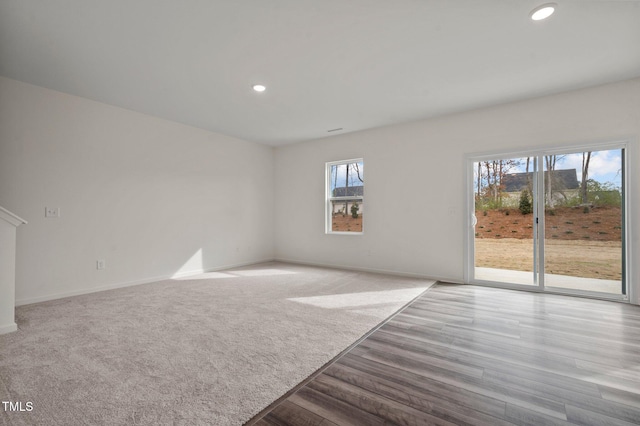 unfurnished living room with baseboards, wood finished floors, and recessed lighting