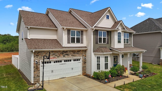 view of front of home with a garage, a front lawn, a shingled roof, and stone siding
