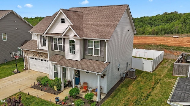 view of front facade with fence, central air condition unit, driveway, roof with shingles, and a front yard