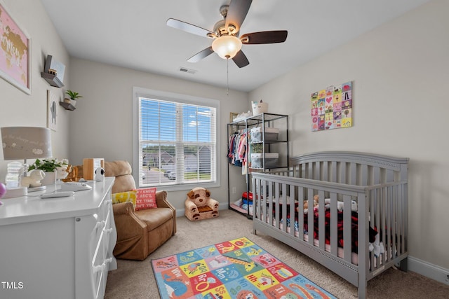 bedroom with baseboards, a crib, visible vents, and light carpet